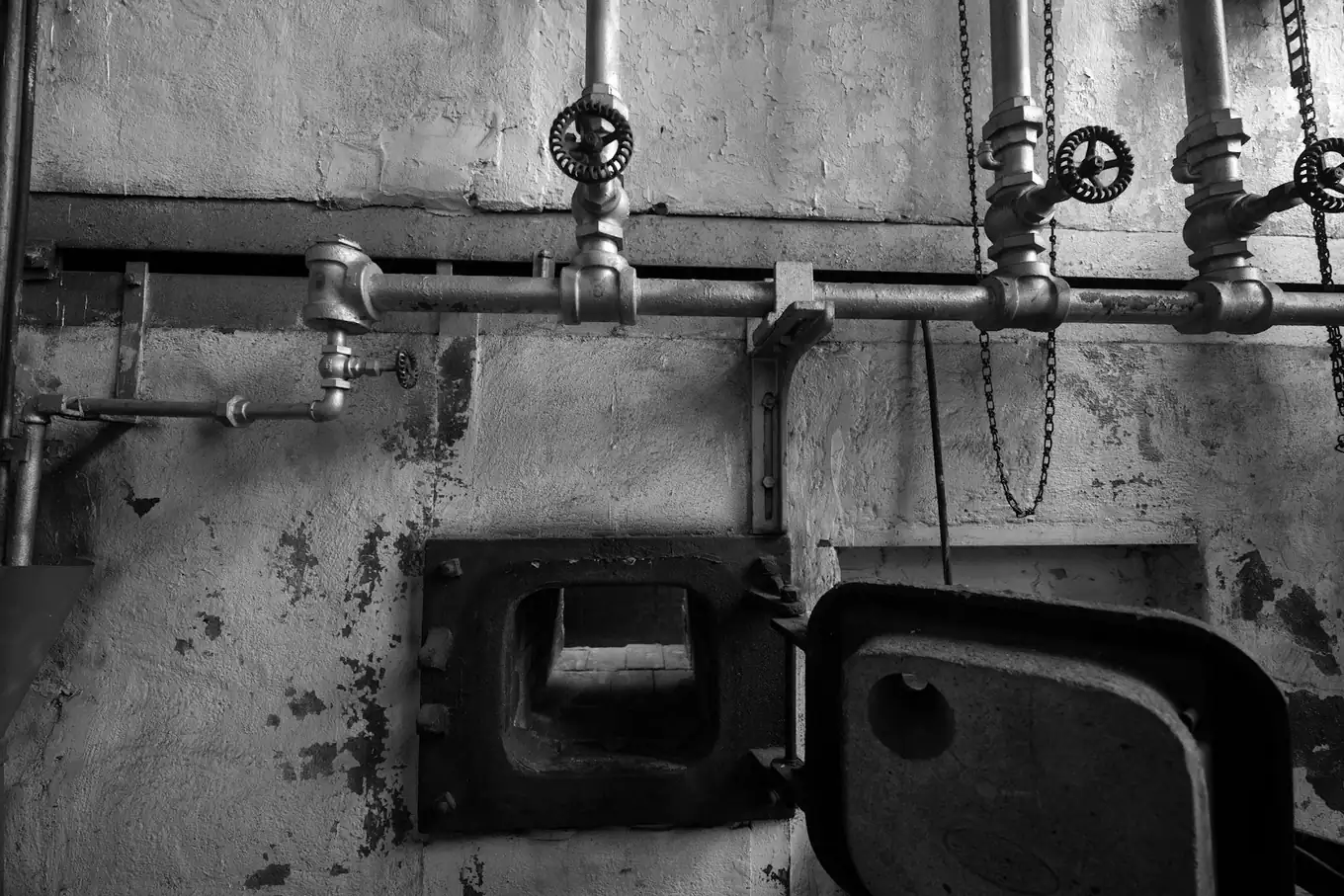 Boiler room pipes and valves above an open furnace door