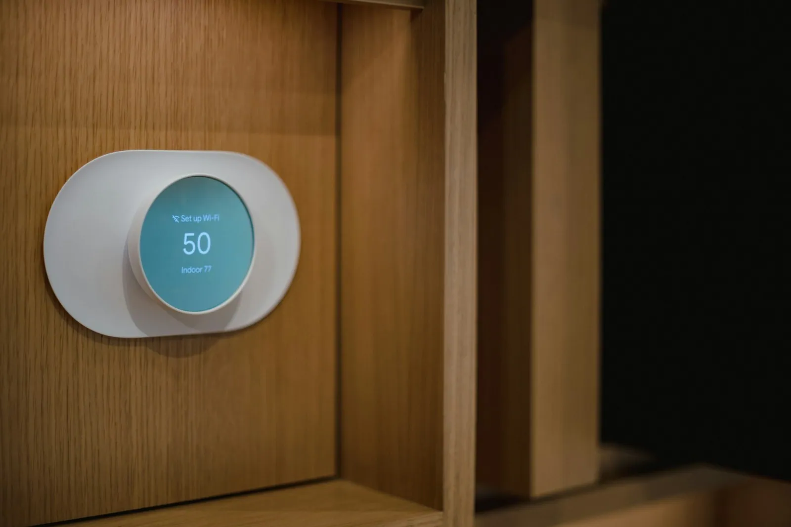 Smart thermostat mounted on a wood-paneled wall