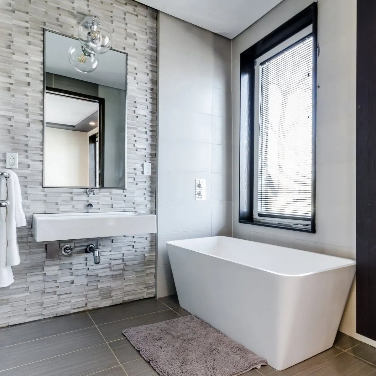 Bathroom with freestanding tub and stone accent wall