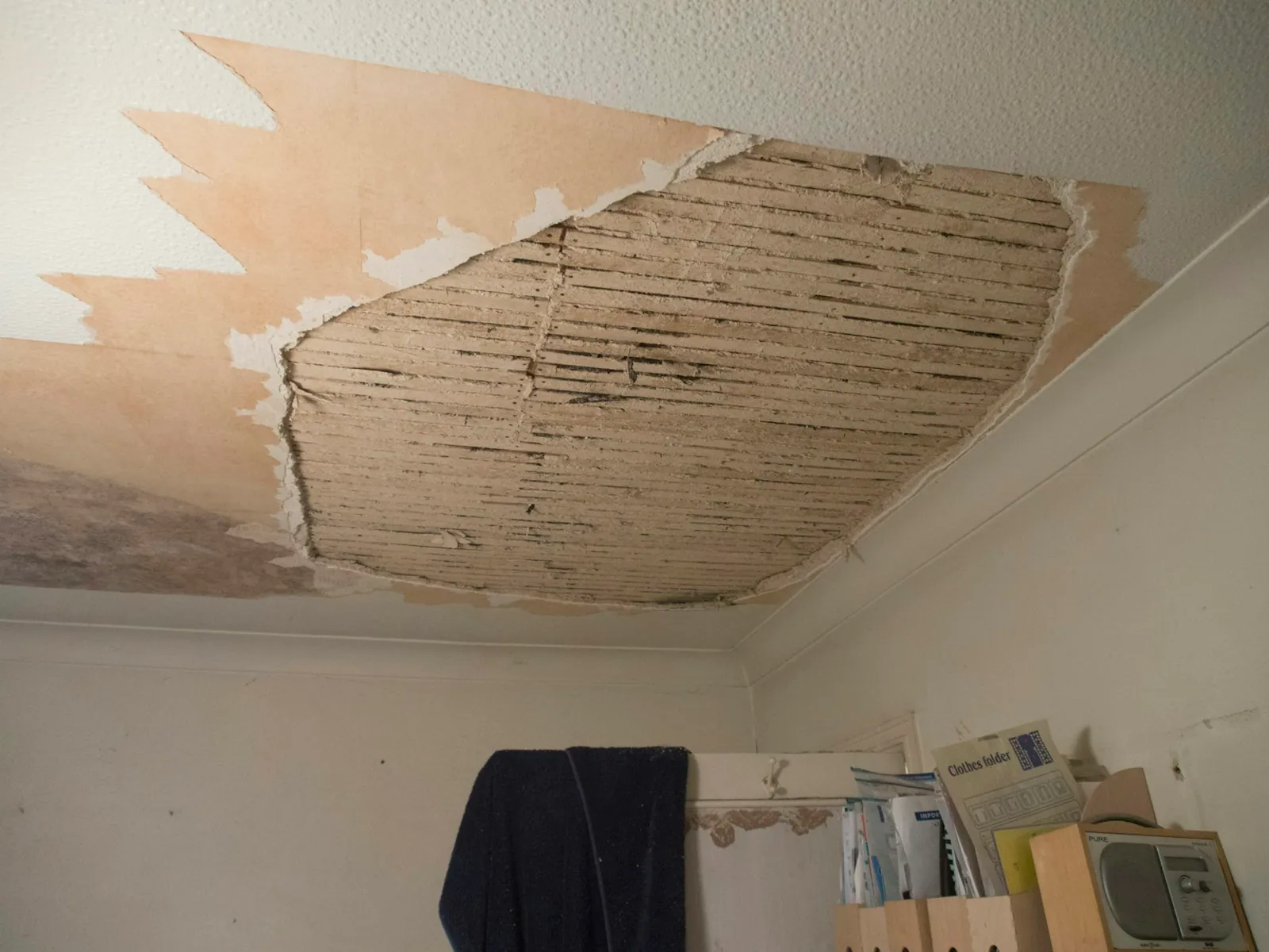 Room with a damaged ceiling torn open down to the joists