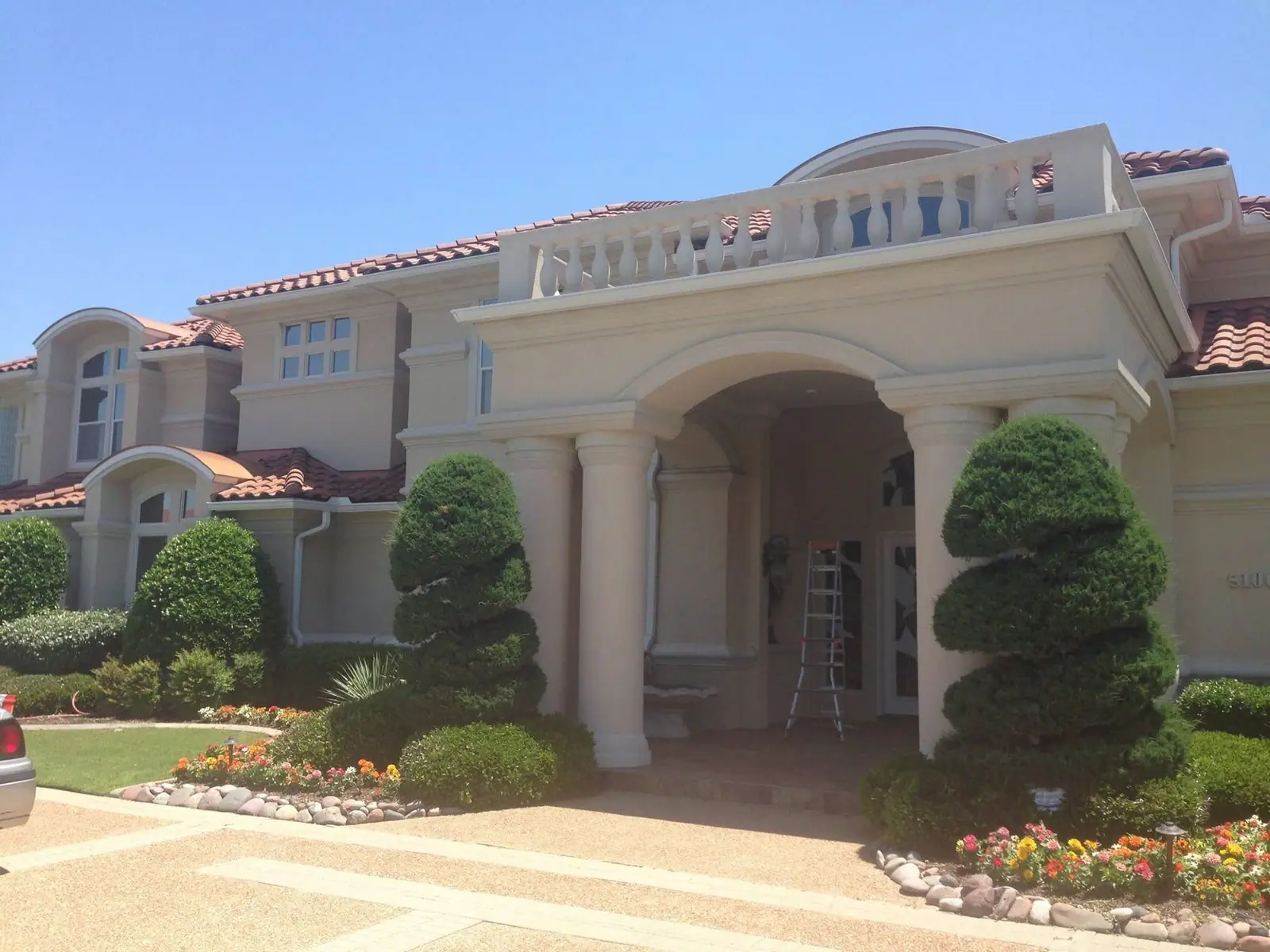 Two-story stucco home with a tile roof and arched entry