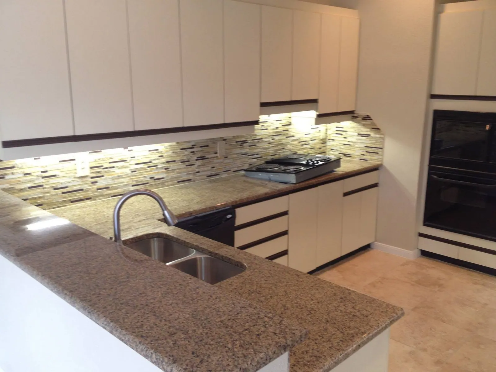 Modern kitchen with white flat-panel cabinets and granite counters