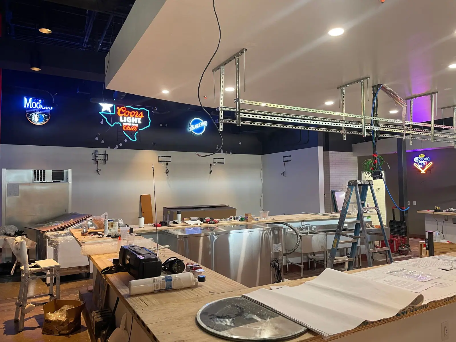 Restaurant bar under construction with neon signs and ceiling soffits