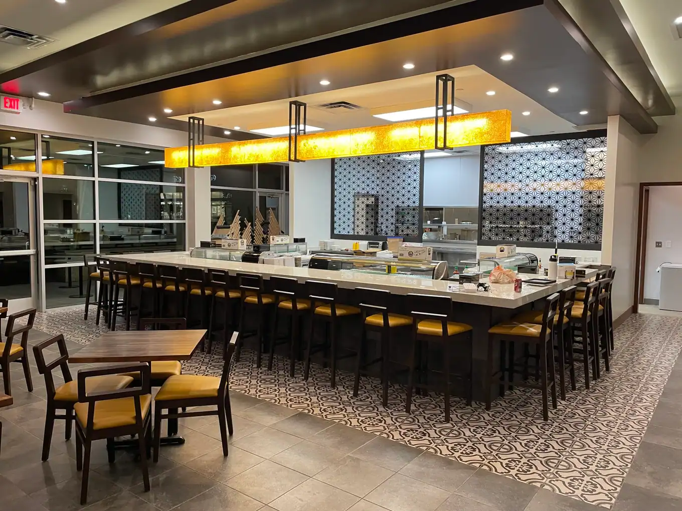 Finished restaurant dining room with a long bar and pendant lights