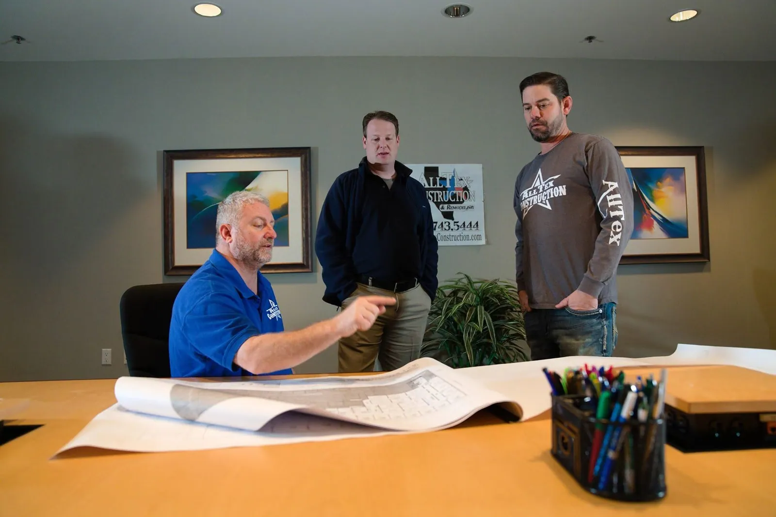 AllTex team reviewing a large set of blueprints on a conference table