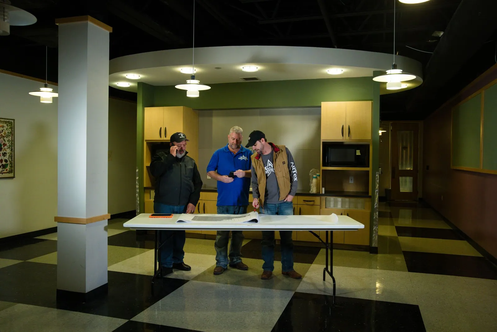 AllTex team walking a finished commercial lobby with plans on a table