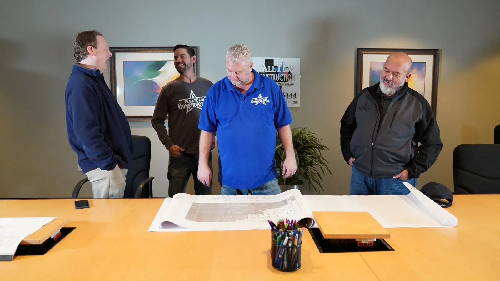 AllTex team gathered around a plan table reviewing drawings