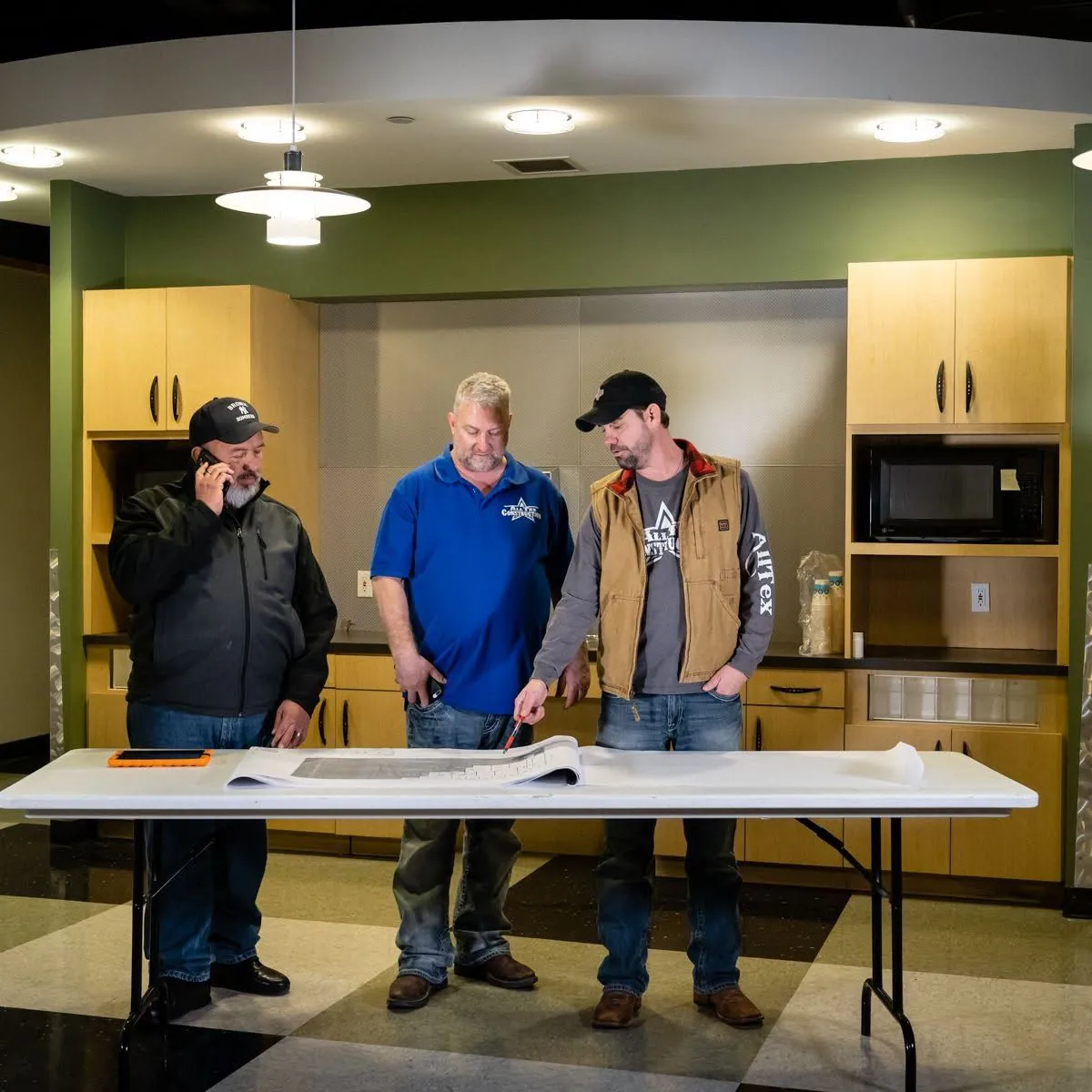AllTex superintendents and crew reviewing plans on a table at a job site