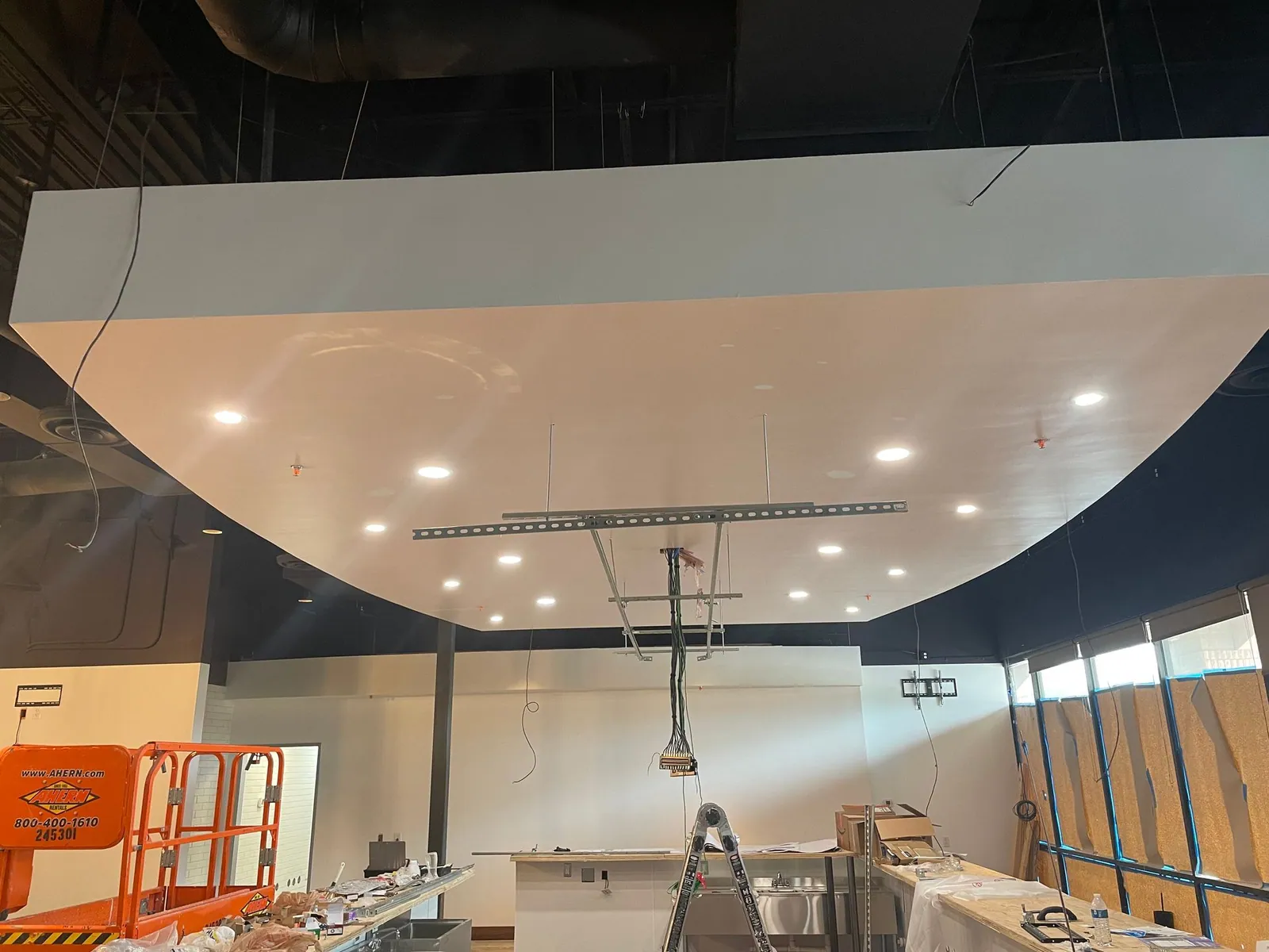 Curved ceiling soffit with recessed lights being finished in a commercial suite