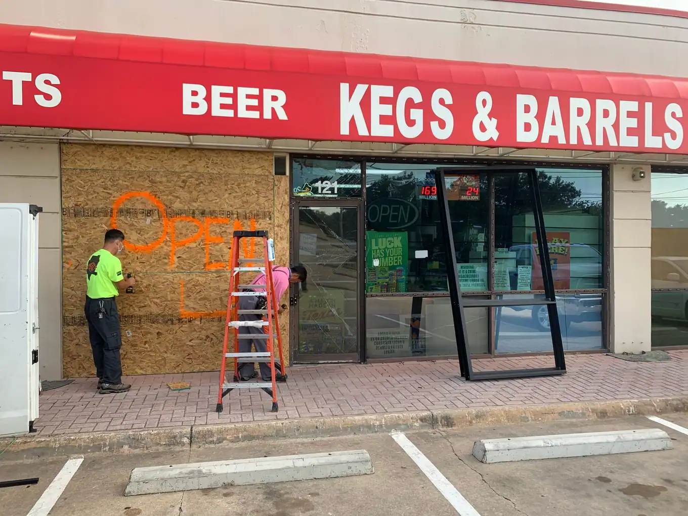Crew installing a new storefront door in a retail strip center