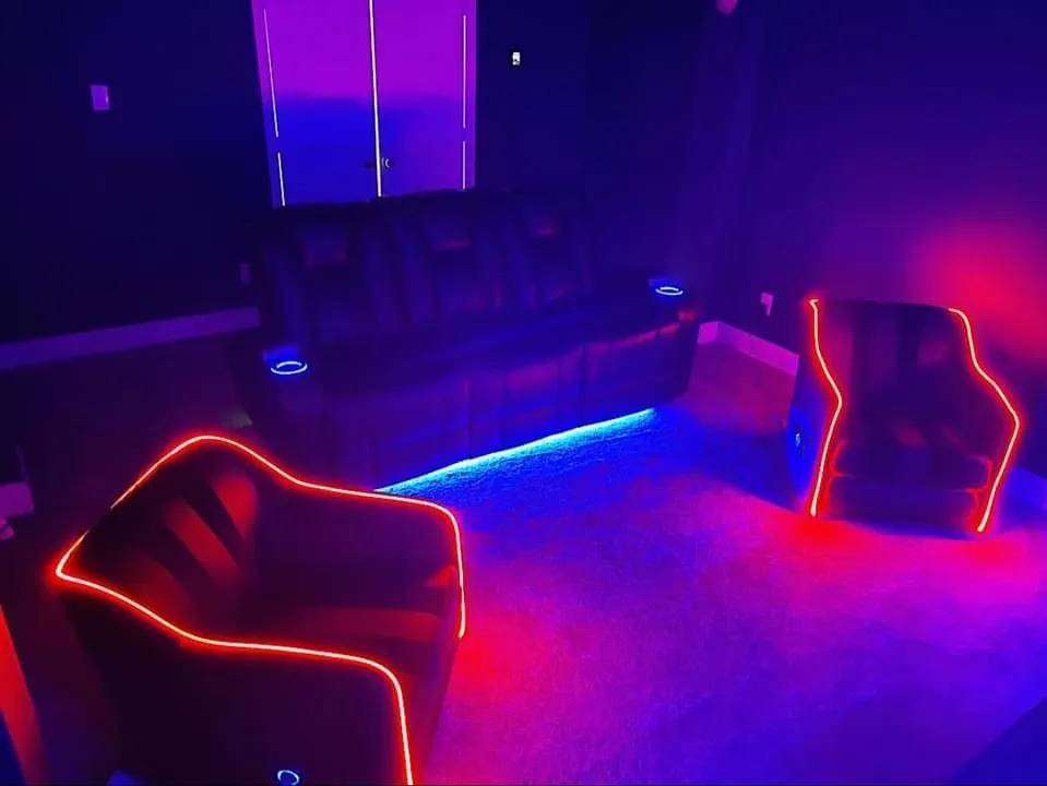 Home media room with LED-lit recliners glowing red
